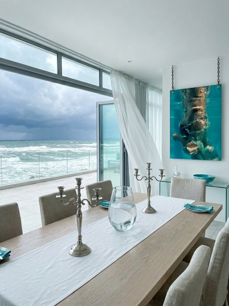"Culto al Cuerpo" archival print on aluminium in a rustic beach room with sand floor, vintage lantern and open ocean door — ConelAlma ESP