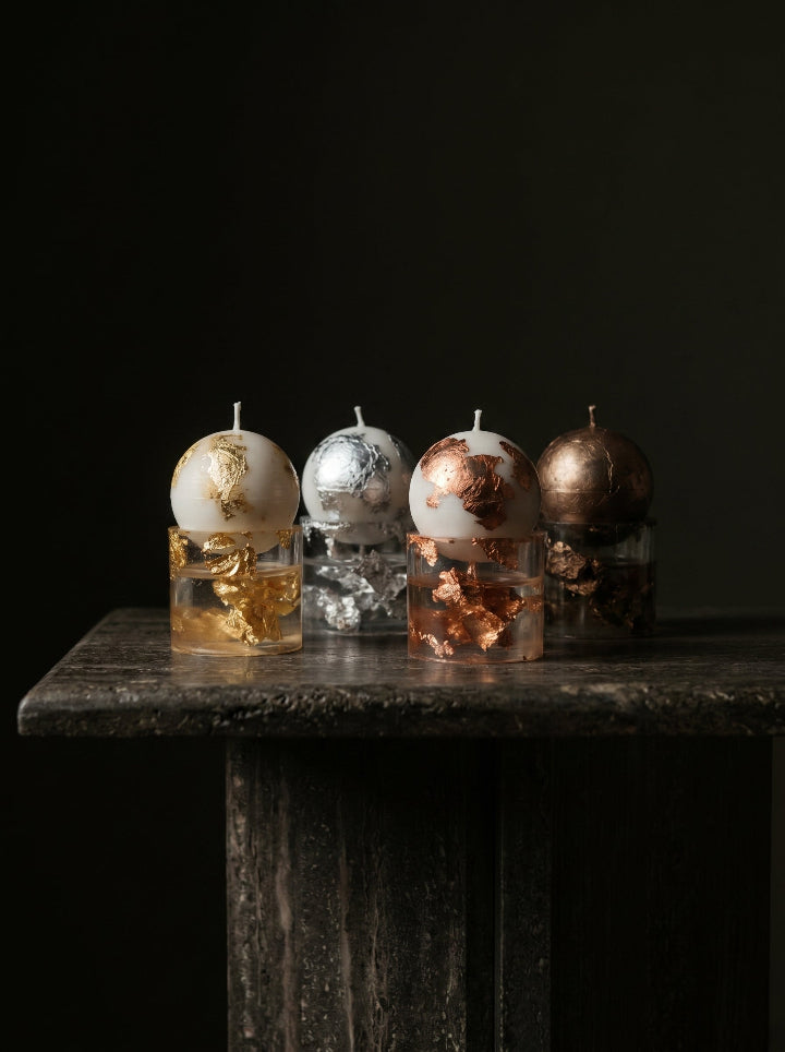 Gilded Relic beeswax sphere candle on gold resin stand – front view