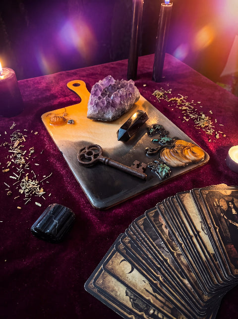 Salem Board with crystals, an antique key and tarot cards on a candlelit table