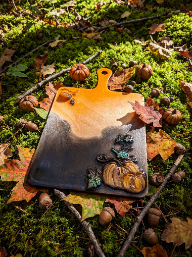 Salem Board pumpkin resin art on moss among autumn leaves and acorns